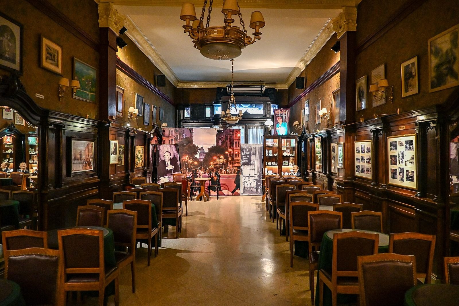 Interior do Café Tortoni, com quadros e mesas de madeira